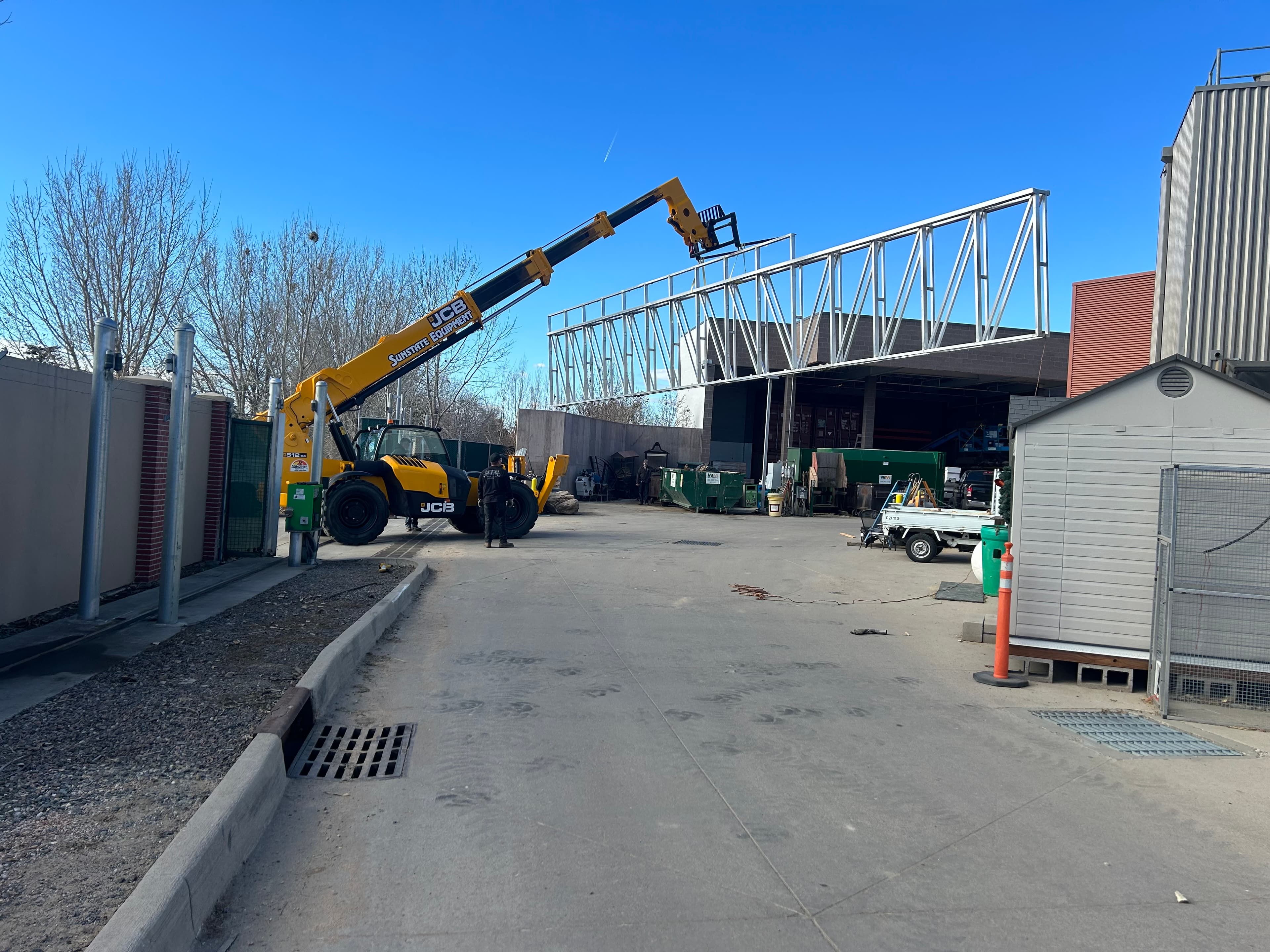 Installing a 65’ x 12’ aluminum slide gate up and over perimeter wall in Denver, CO