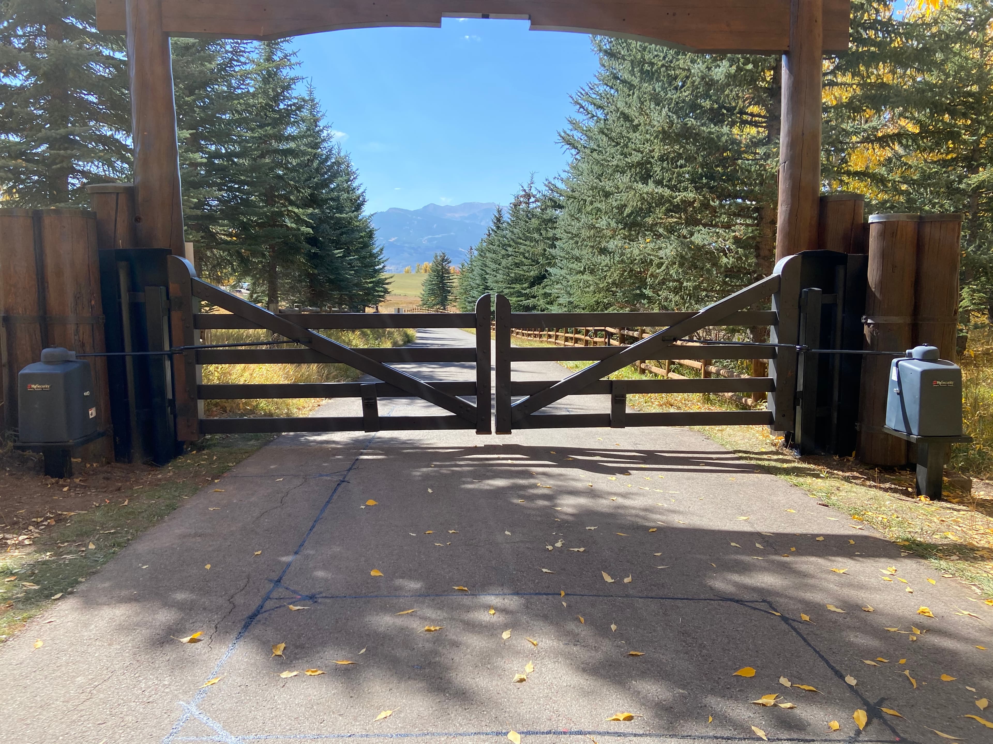 Bi-parting wood swing gate system with HySecurity Swing Smart operators on steel pedestals in Aspen, CO