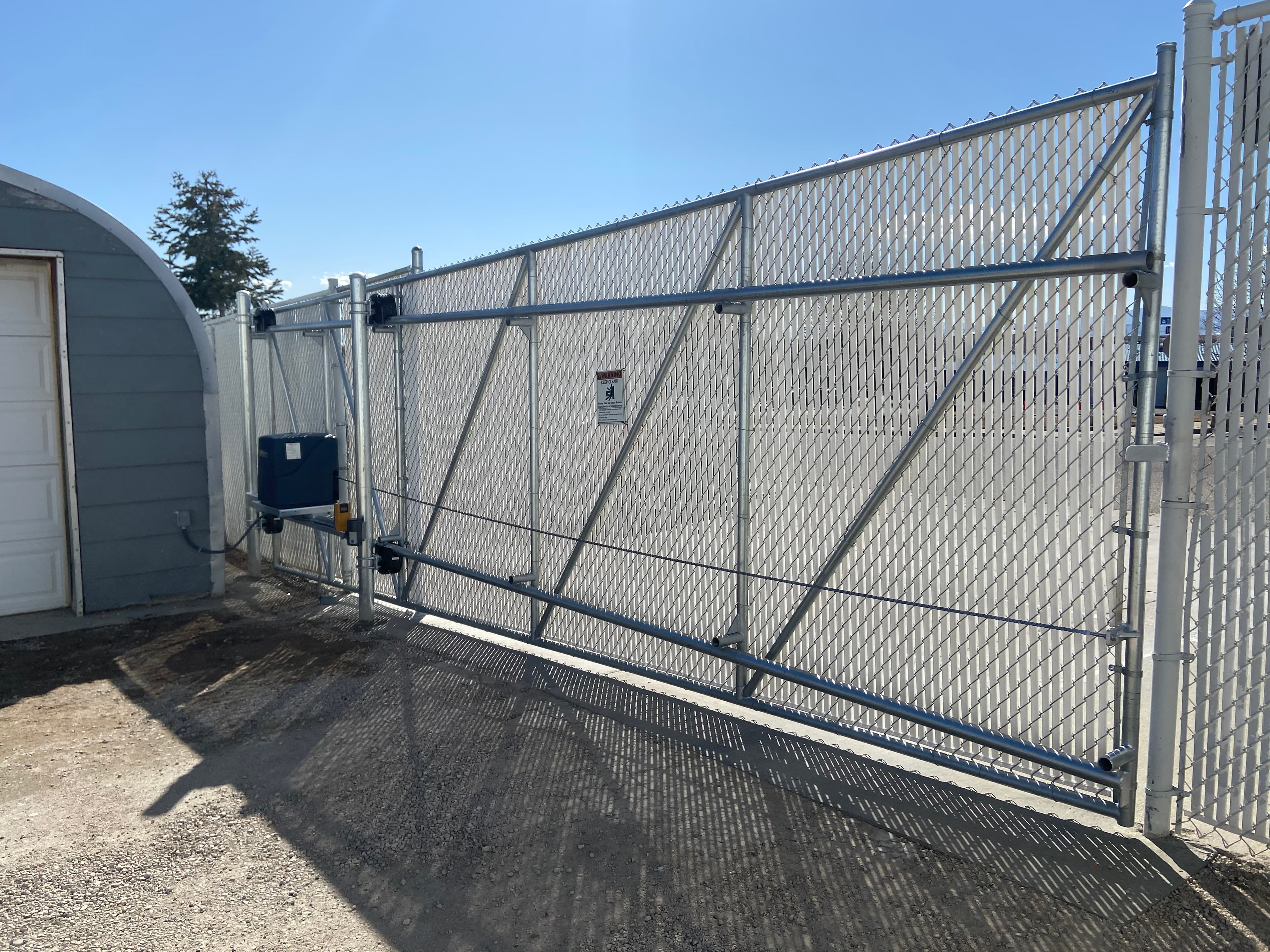 Automated chain-link cantilever slide gate with biased frame to match driveway grade in Broomfield, CO