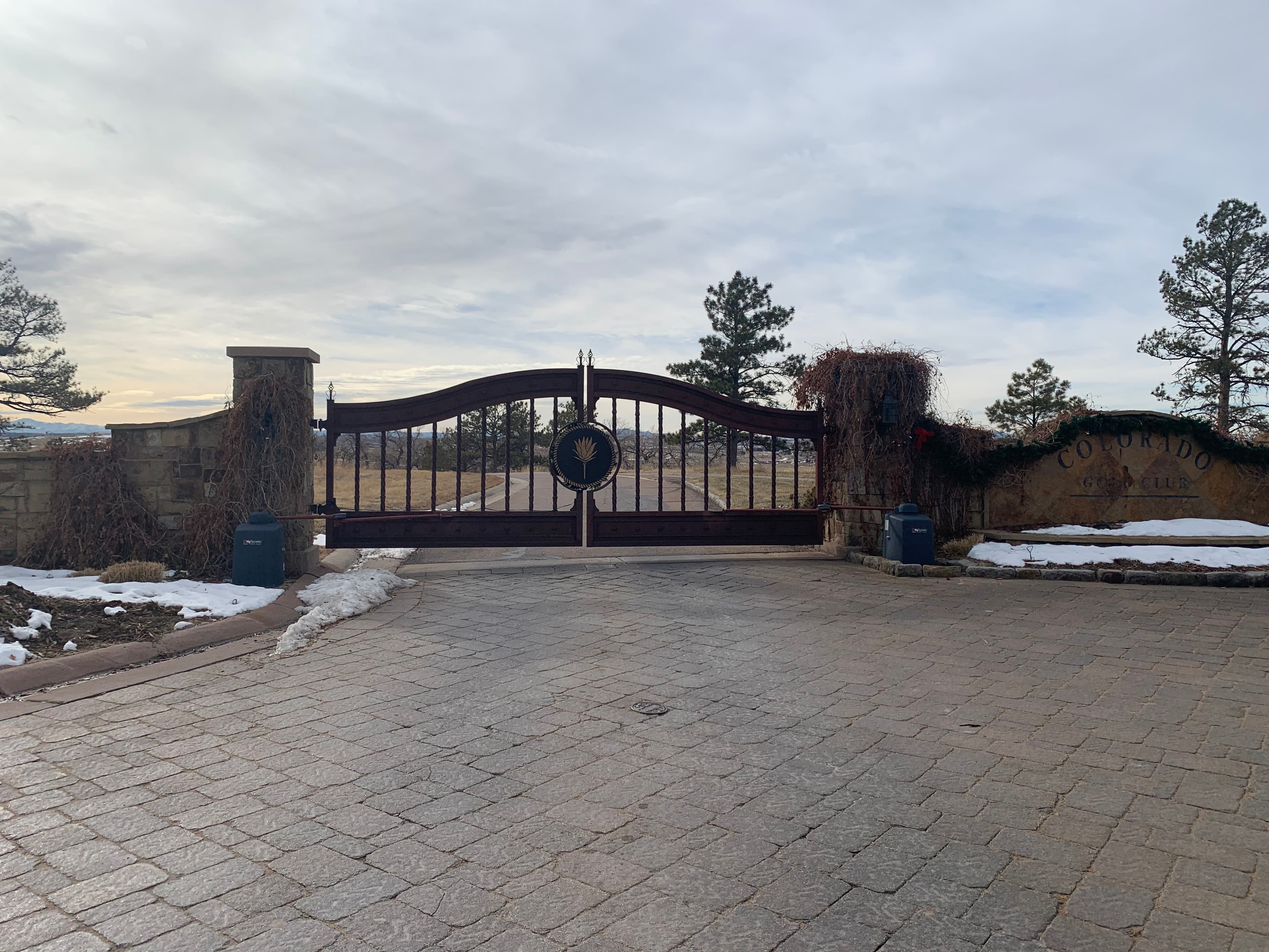 Custom ornamental iron swing gates with scrollwork and community logo in Parker, CO