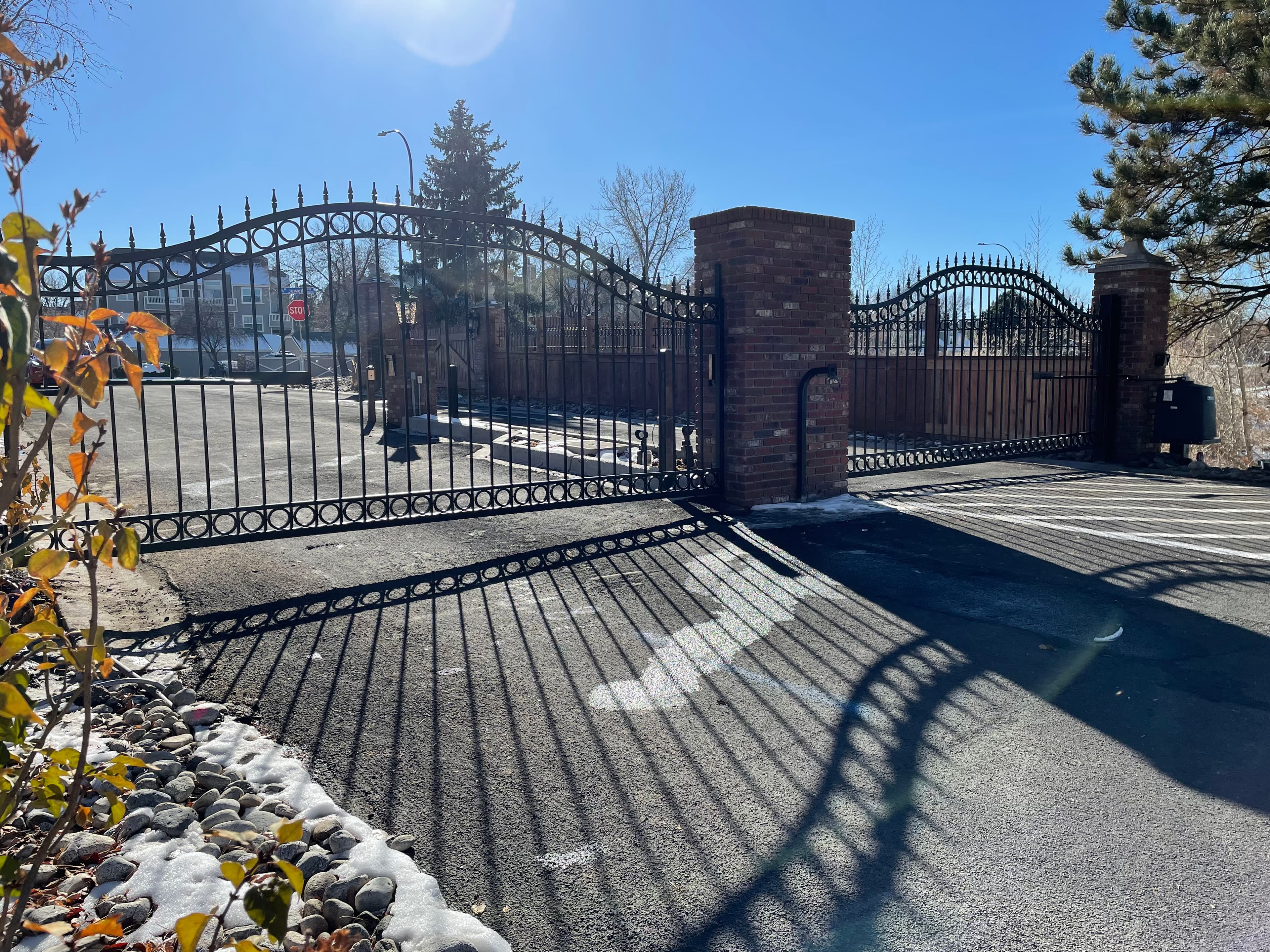 Ornamental arch-top entry/exit swing gates with HySecurity DC20 and DoorKing 1835 in Littleton, CO