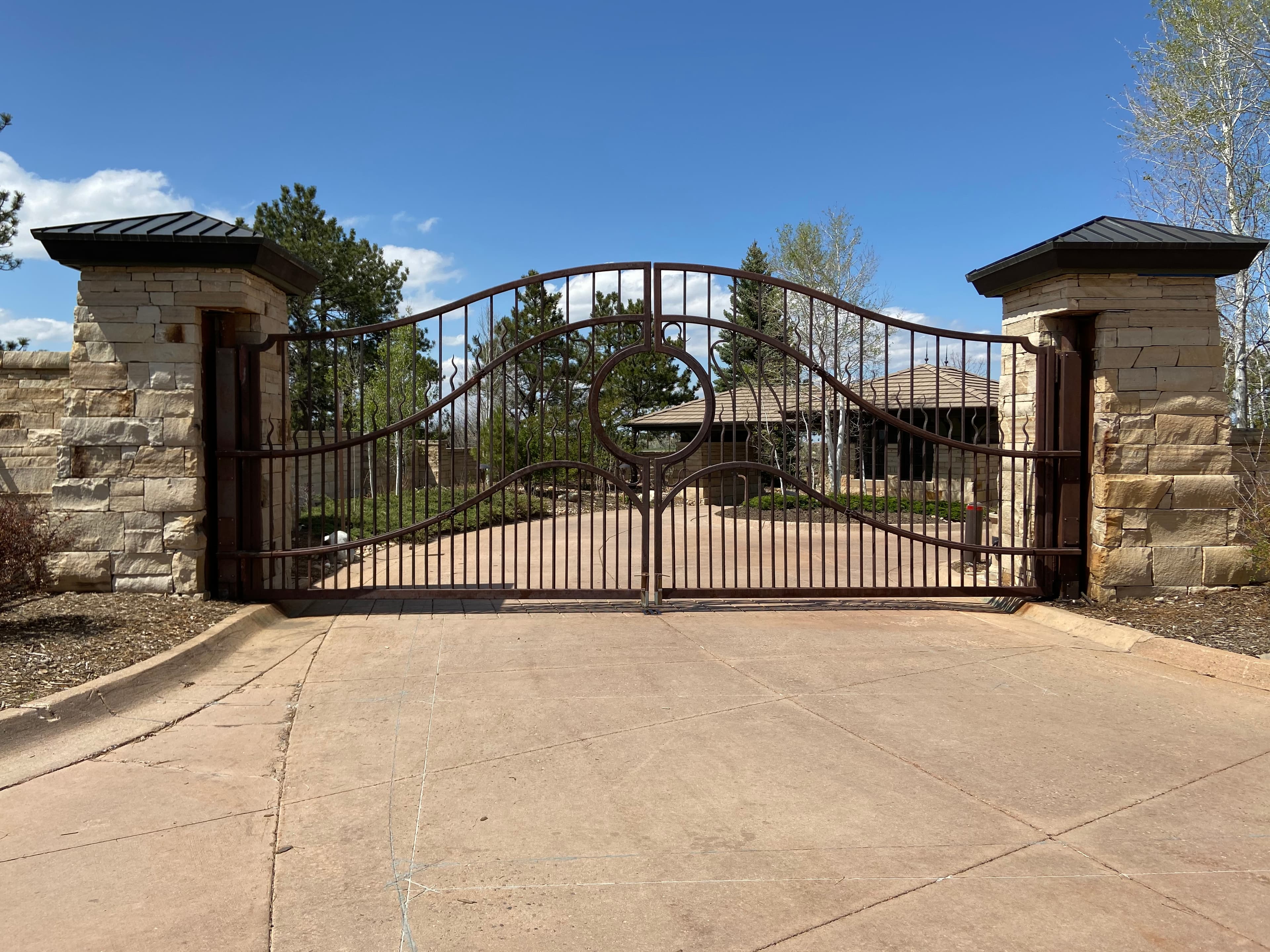 Custom ornamental iron scrolling arch-top swing gates with HySecurity Swing Riser operators in Castle Pines, CO