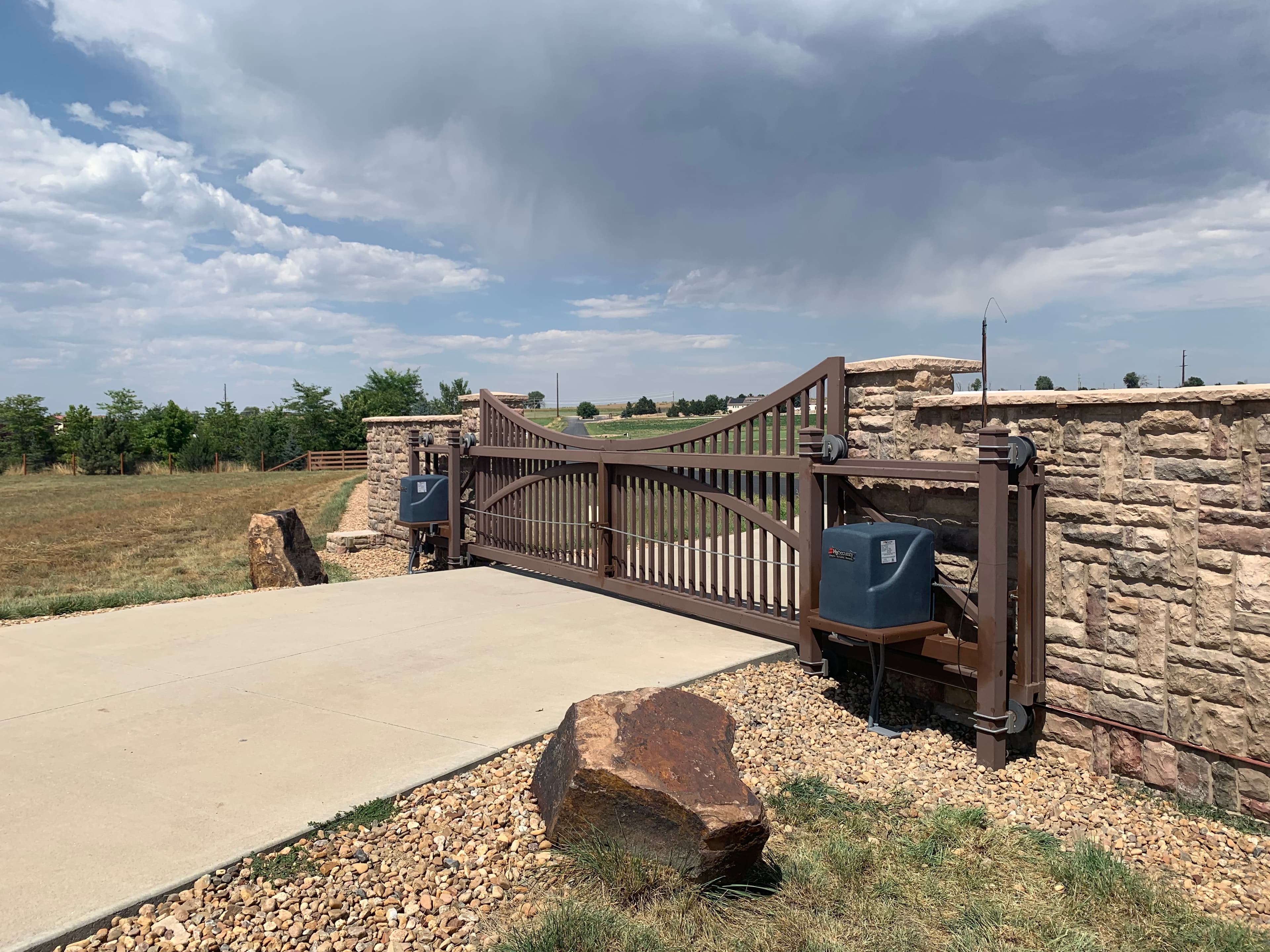Ornamental iron bi-parting cantilever slide with reverse arch top and rust finish in Fort Collins, CO